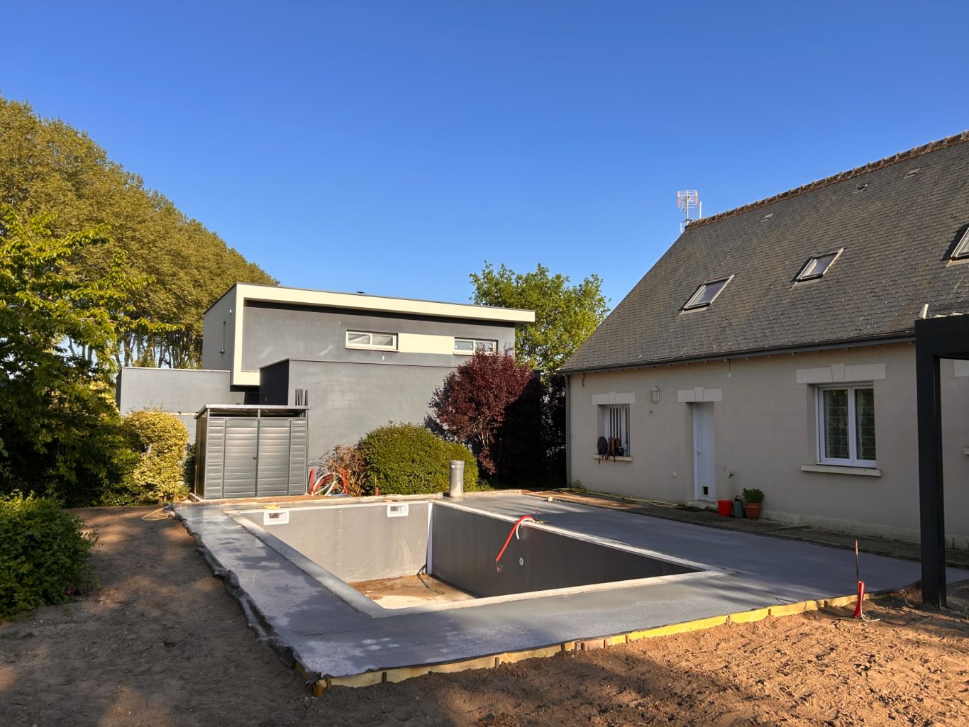 Coulage des plages de la piscine Construction d'une piscine à côté d'une maison moderne et d'une maison traditionnelle.