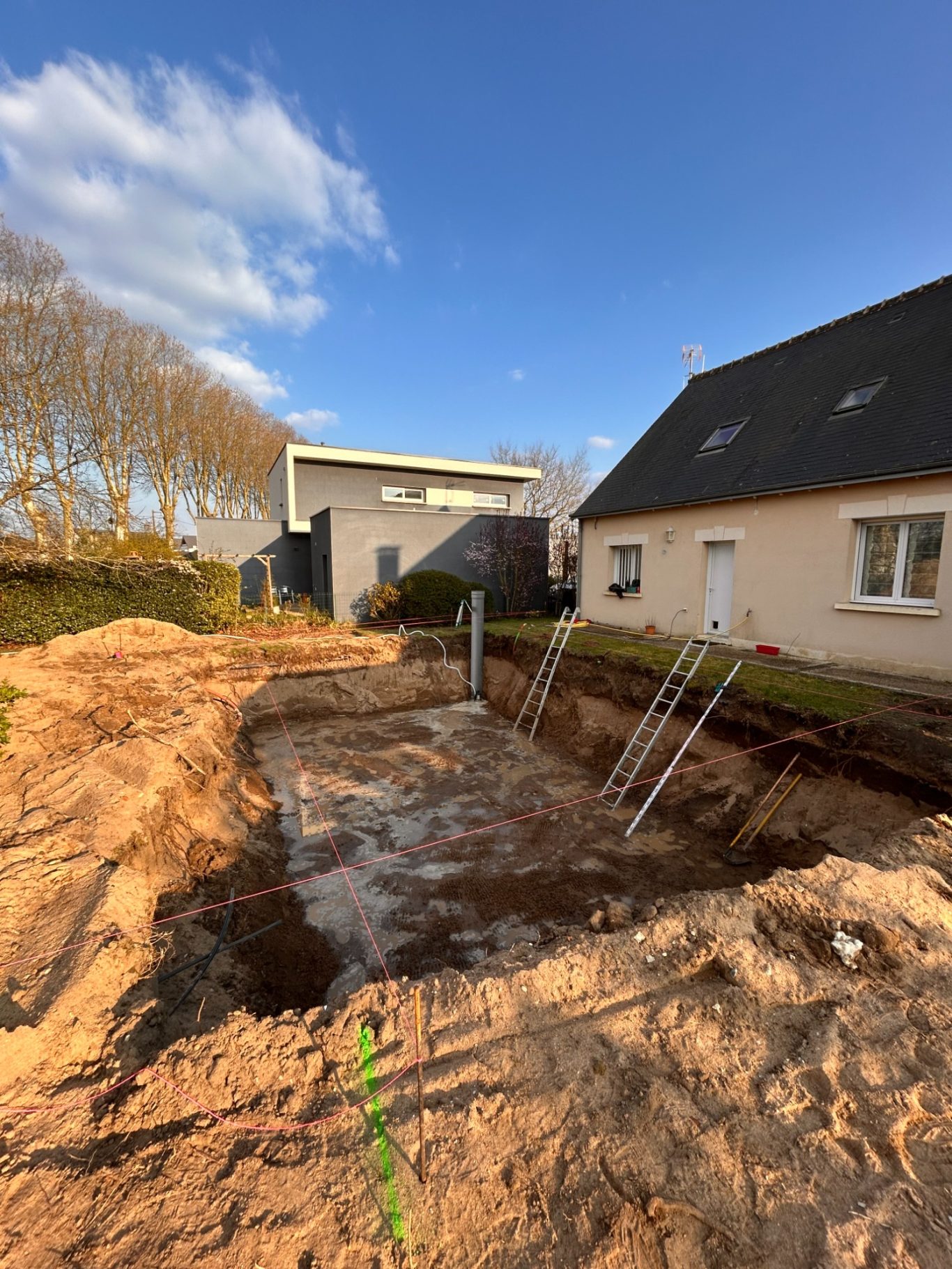 Terrassement Terrassement pour un chantier, excavation avec échelle et bâtiments en arrière-plan.