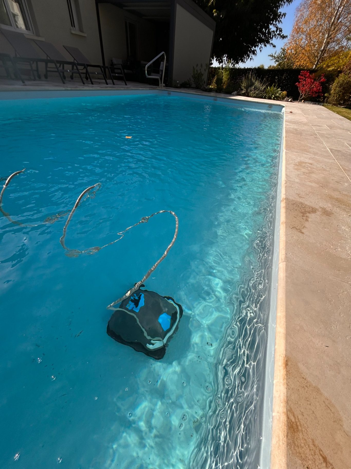 Robot de piscine ZODIAC Robot de nettoyage de piscine flottant dans une eau claire et bleue.